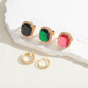 Detailed view of colorful square zircon rings with 14K gold plating on stone texture