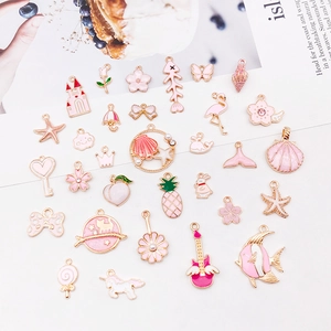 Pink and gold enamel charms collection featuring fishbone shells and floral motifs