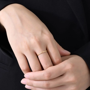 Minimalist 1mm gold titanium steel ring with colorful zircons worn by a model