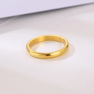 Minimalist 3mm polished gold stainless steel ring for couples on a simple grey backdrop
