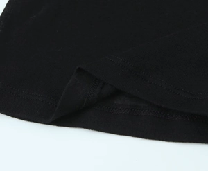 Close-up of black fabric with precise double-needle stitching and hemline details
