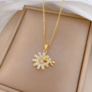 Macro shot of gold-plated dragonfly and daisy pendant necklace with sparkling zircons