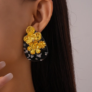 Vintage gold flower resin earrings with black geometric oval base on model