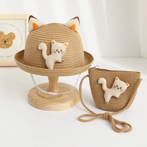 Detail of straw hat set with cute cat ears and matching crossbody bag for children