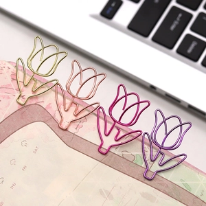 Close-up of tulip-shaped metal paperclips in gold and rose gold on a calendar planner