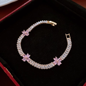 Detailed view of pink zircon flower bracelet on premium black velvet jewelry box tray