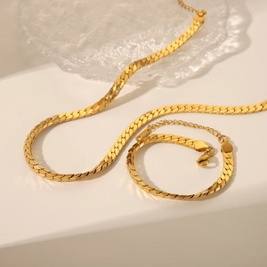 Vue détaillée de l'ensemble collier et bracelet à maille serpent dorée sur fond blanc