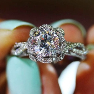 Détail macro d'une bague fleur en argent avec un grand zircon et un anneau torsadé pavé