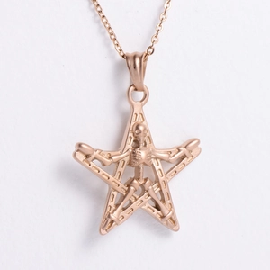Close-up of rose gold punk necklace featuring pentagram and skull charm pendant