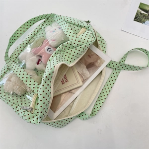 Detail view of the green polka dot canvas bag with a large transparent PVC window display