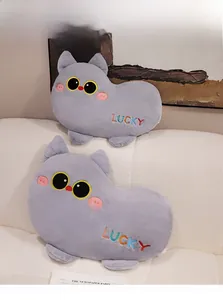 Detail of plush cat pillows with LUCKY embroidery and soft fabric on a white sofa