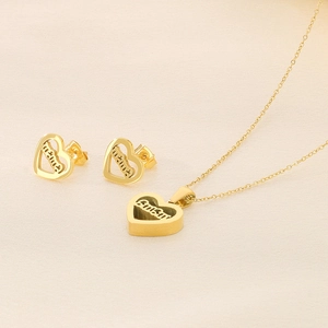 Detail of gold heart jewelry set with mama engraving on necklace and earrings