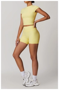 Dettaglio del set yoga giallo con pantaloncini a vita alta e crop top elastico
