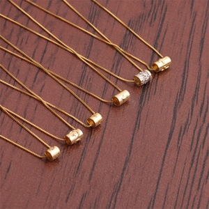 Close-up of golden box chain necklaces with assorted cylindrical lucky eye pendants