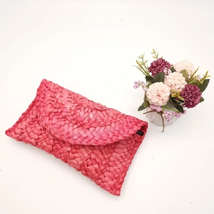 Pochette a busta rosa in paglia di mais intrecciata con texture naturale e decoro floreale