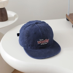 Détail de la casquette à bord plat en coton délavé bleu foncé avec broderie blanche