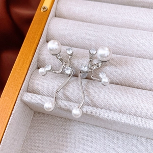 Detail shot of silver earrings with white pearls and zircons in a jewelry box