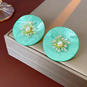 Makroaufnahme der minzgrünen runden Harzohrringe mit Perle und Kristall Sonnenblumen-Design