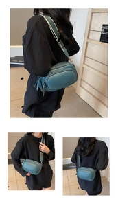 Detail of teal crossbody bag with lychee leather texture and striped wide shoulder strap