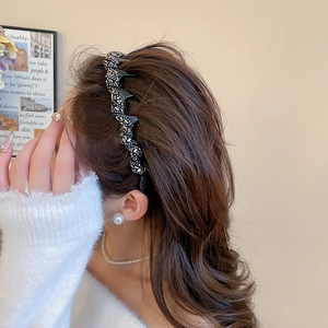 Detail of wavy black rhinestone headband worn on brown hair for an elegant look