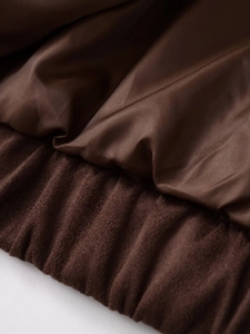 Detailansicht des dunkelbraunen Satinfutters und der dicken Rippstrickbündchen-Textur
