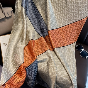 Détail d'un foulard en soie avec motifs grecs géométriques en beige et orange