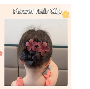 Vue détaillée de deux pinces à cheveux fleurs rouge foncé mat portées par une fille