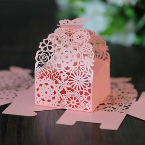 Pink laser-cut wedding candy boxes with butterfly top and floral hollow-out pattern