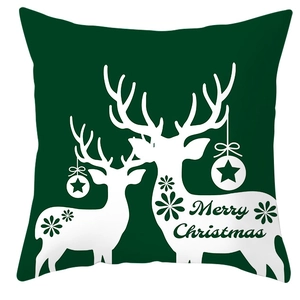Detail of forest green Christmas pillow cover with white reindeer silhouette and star print