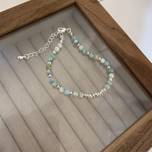 Detailed macro of light blue natural stone beads and silver lobster clasp on bracelet