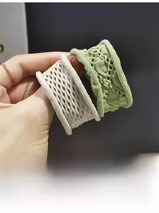 Détail des chouchous élastiques avec motifs en dentelle de couleur blanc et vert clair