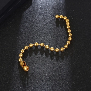 Macro shot of polished gold metal beaded chain bracelet with a matching secure clasp