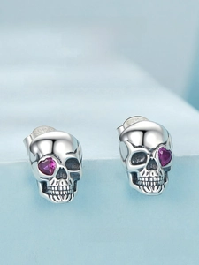Close-up of S925 silver skull earrings with heart-shaped purple zirconia stones