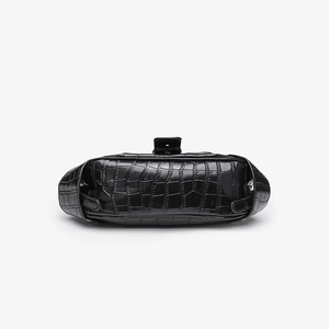 Top view of black crocodile pattern handbag showing buckles and textured leather detail