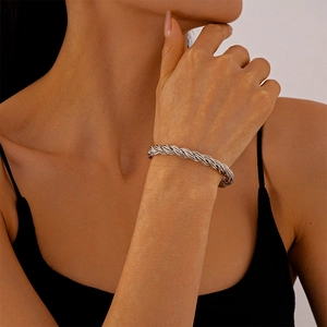 Close-up of minimalist silver twisted rope bangle bracelet on a female wrist