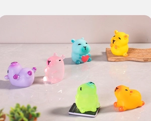 Set of six colorful translucent resin Capybara miniatures on a reflective marble surface