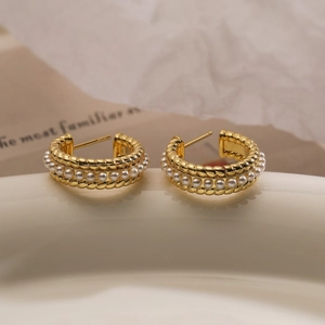 Elegant gold-plated C-shaped hoop earrings with white pearls and woven metal texture