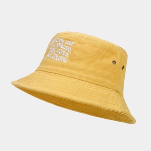 Détail d'un chapeau bob jaune en coton avec broderie blanche et œillets d'aération
