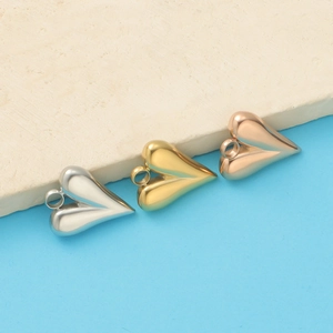 Polished heart pendants in silver, gold, and rose gold finish on a textured stone base