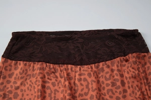 Gros plan d'un pantalon léopard évasé avec bordure en dentelle marron à la taille haute
