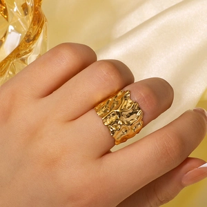 Anello largo placcato oro 18K con trama lavica irregolare indossato su seta pregiata