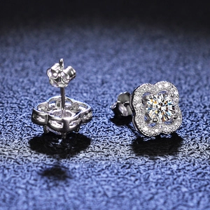 Macro shot of silver four-leaf clover moissanite stud earrings with pavé set accents