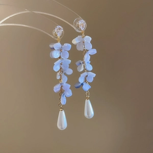 Detail of floral tassel earrings with purple petals and white teardrop pearls