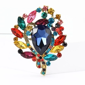 Detailed macro view of vintage alloy brooch with colorful rhinestones and blue pear gem