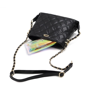 Detail of black quilted PVC sunglass bag with gold hardware and laser effect wallet insert