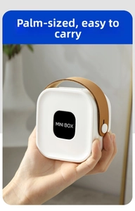 Detailed view of the compact white MINI BOX organizer with a brown leather handle strap