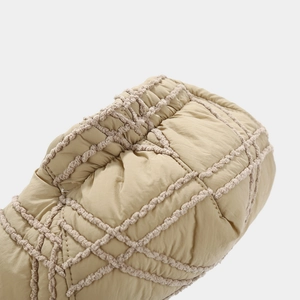 Macro shot of khaki newsboy cap featuring detailed diamond quilted stitching and texture