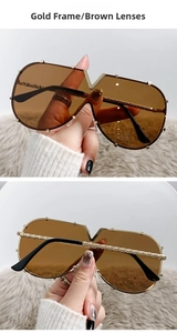 Detail of oversized gold metal sunglasses with brown lenses and woven texture temples