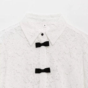 White lace long sleeve shirt with black bow tie details and buttons on white background