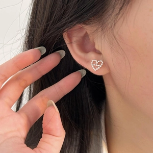 Detailed close-up of hollow heart stud earrings crafted from silver metallic beads